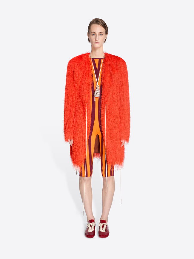 Model wearing a bright orange fringed garment on a white background - Dries Van Noten