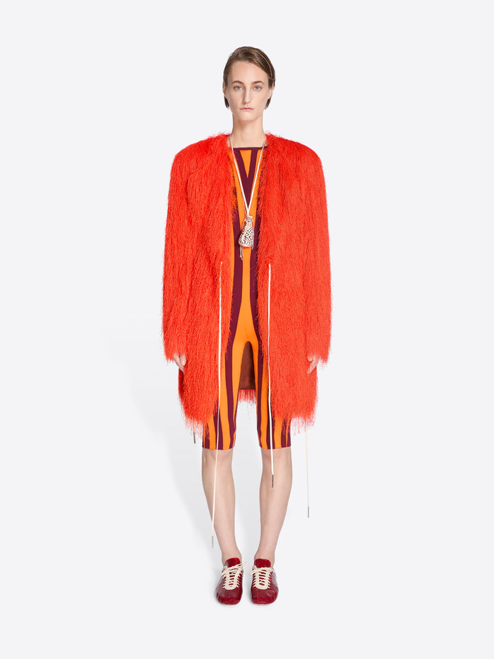 Model wearing a bright orange fringed garment on a white background - Dries Van Noten