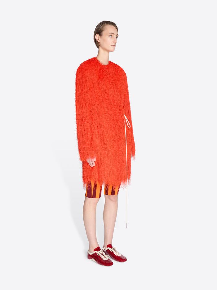 Person wearing a bright orange dress with a white background - Dries Van Noten