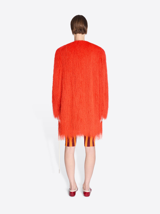 Person wearing a bright orange cardigan on a white background - Dries Van Noten