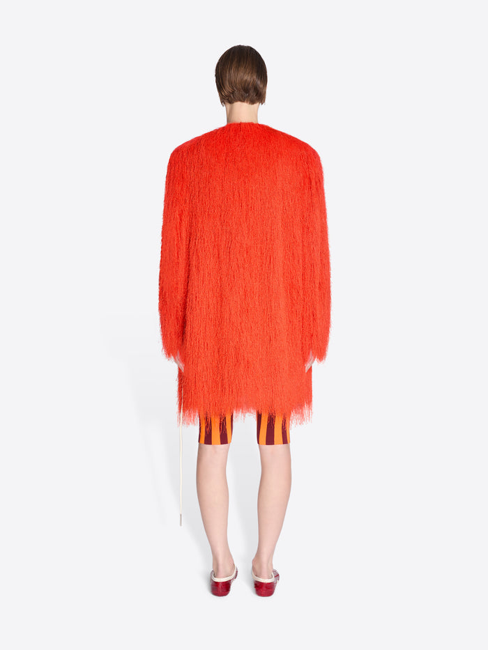 Person wearing a bright orange cardigan on a white background - Dries Van Noten