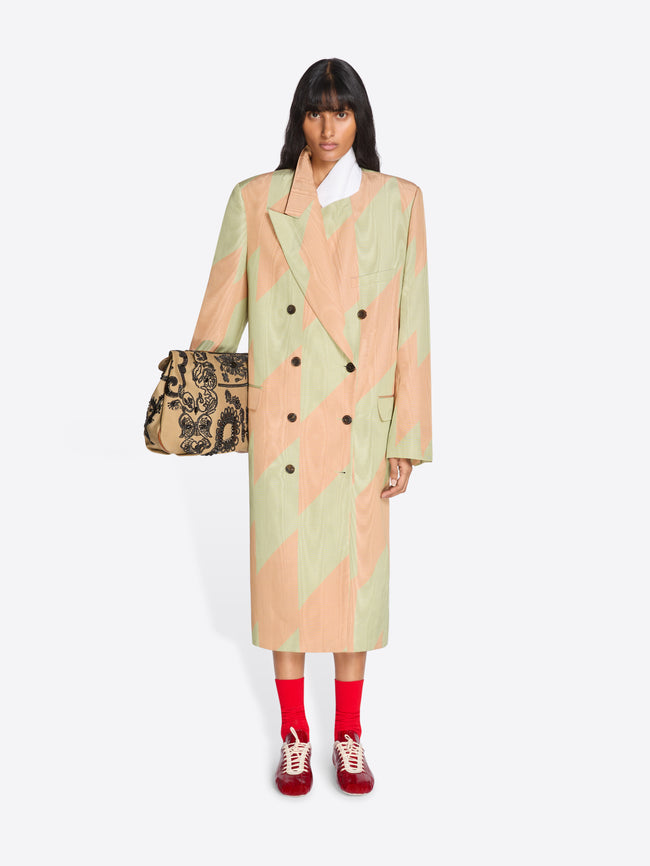 Woman wearing a patterned coat holding a bag on a white background - Dries Van Noten