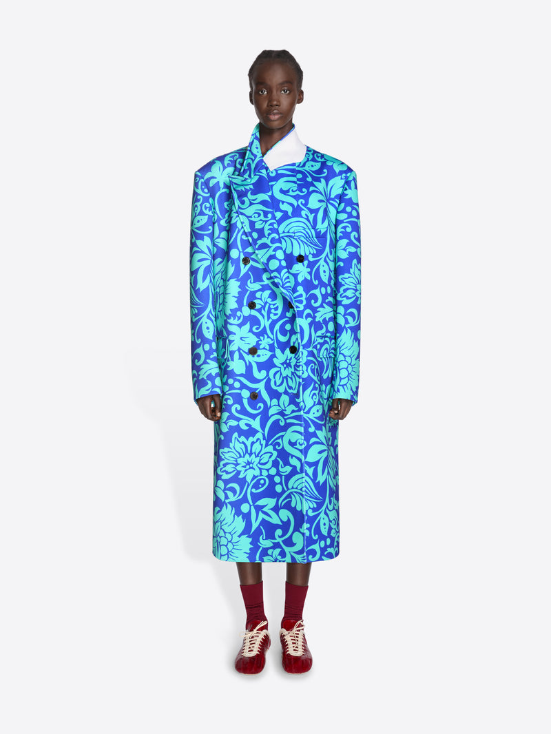 Person wearing a blue floral coat on a white background - Dries Van Noten