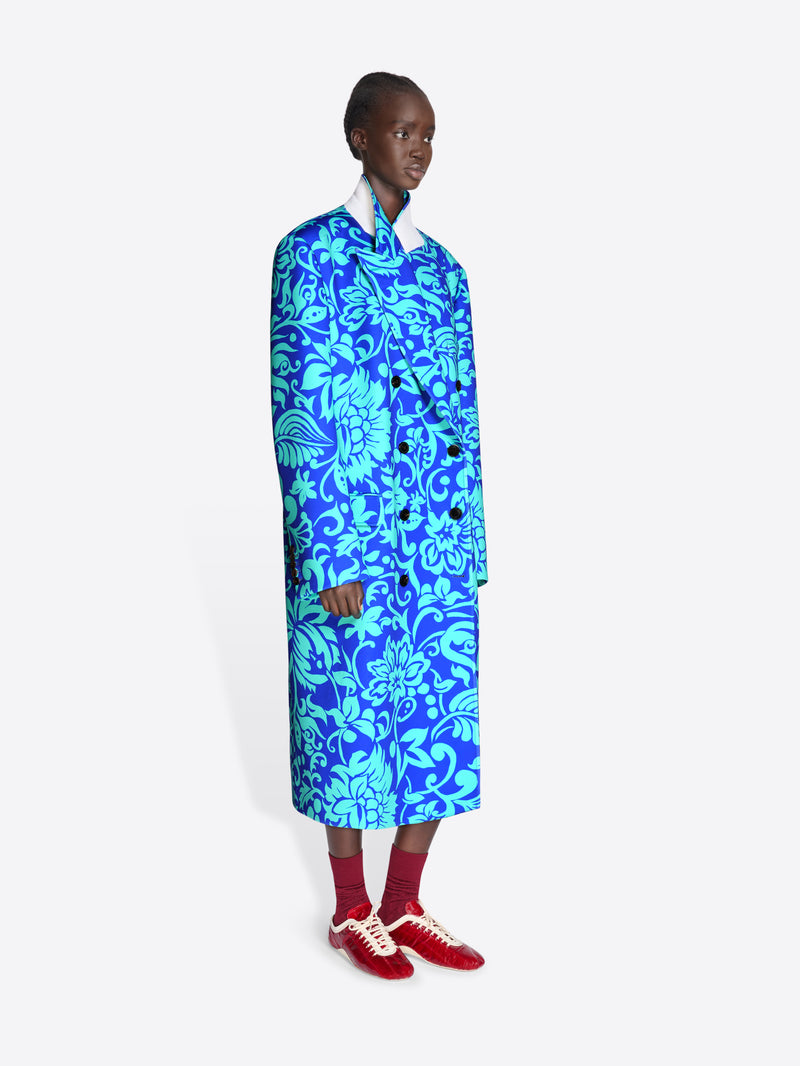 Person wearing a blue floral coat on a white background - Dries Van Noten