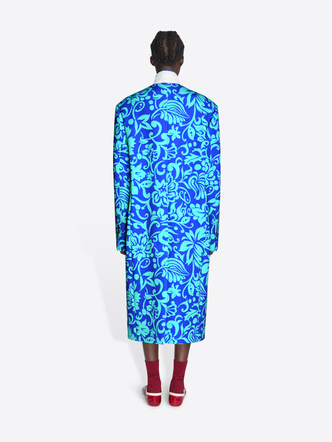 Person wearing a blue floral patterned coat on a white background - Dries Van Noten