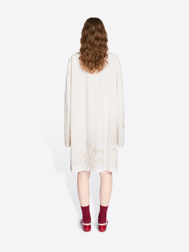 Person wearing a white dress with long sleeves on a white background - Dries Van Noten