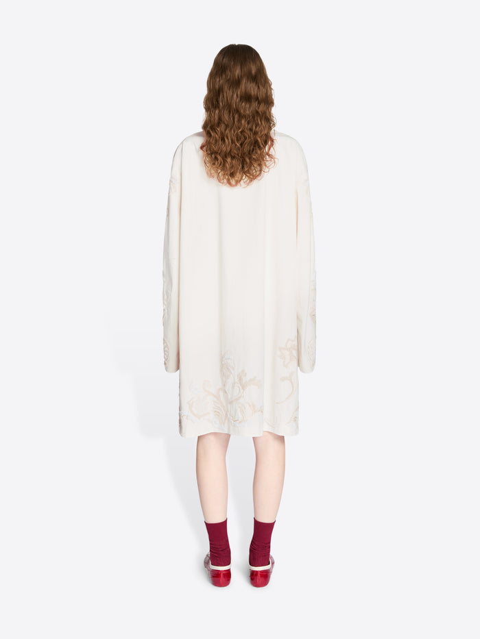 Person wearing a white dress with long sleeves on a white background - Dries Van Noten