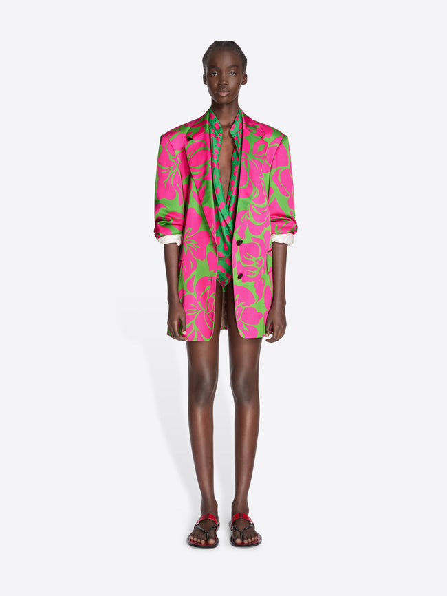 Model wearing a vibrant pink and green patterned suit on a white background - Dries Van Noten