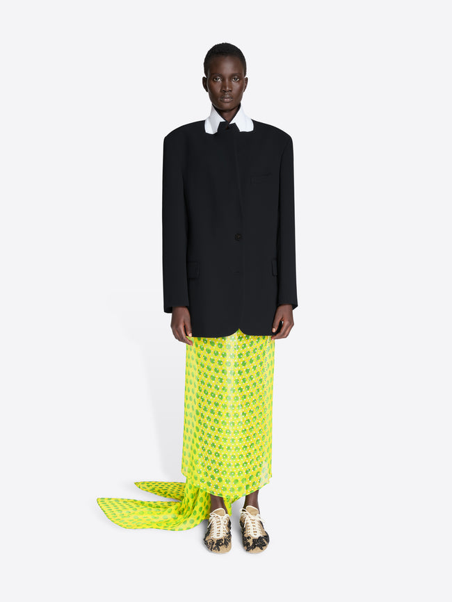 Person wearing a black blazer and bright green patterned pants on a white background - Dries Van Noten