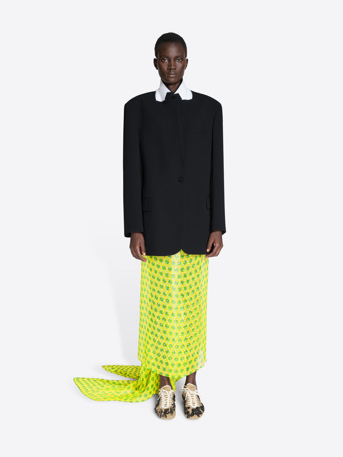 Person wearing a black blazer and bright green patterned pants on a white background - Dries Van Noten