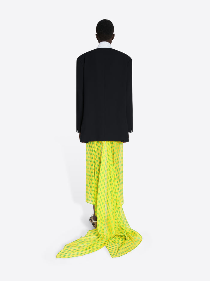 Person wearing a black jacket and bright yellow patterned pants on a white background - Dries Van Noten