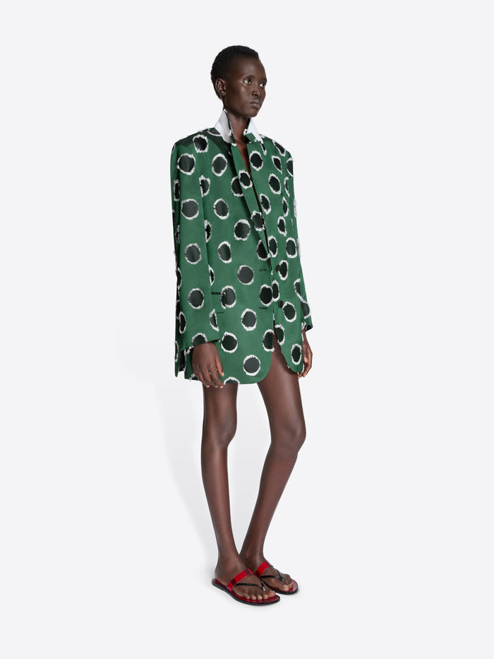 Model wearing a green blazer with black polka dots on a white background - Dries Van Noten