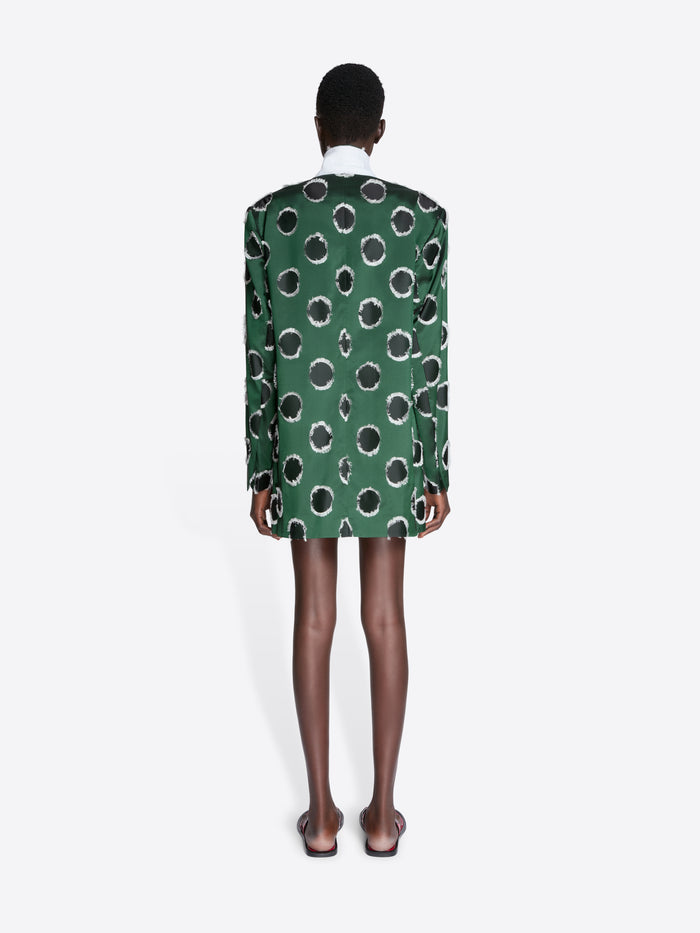 Person wearing a green blazer with black polka dots on a white background - Dries Van Noten