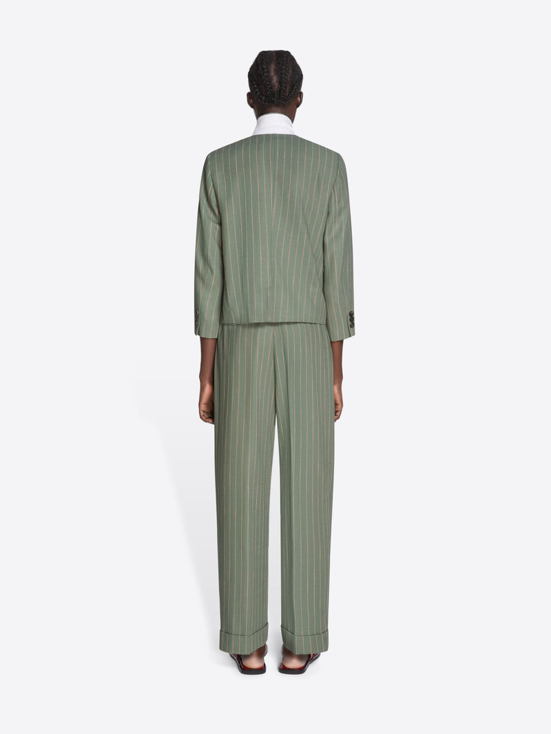 Person wearing a green pinstripe suit on a white background - Dries Van Noten