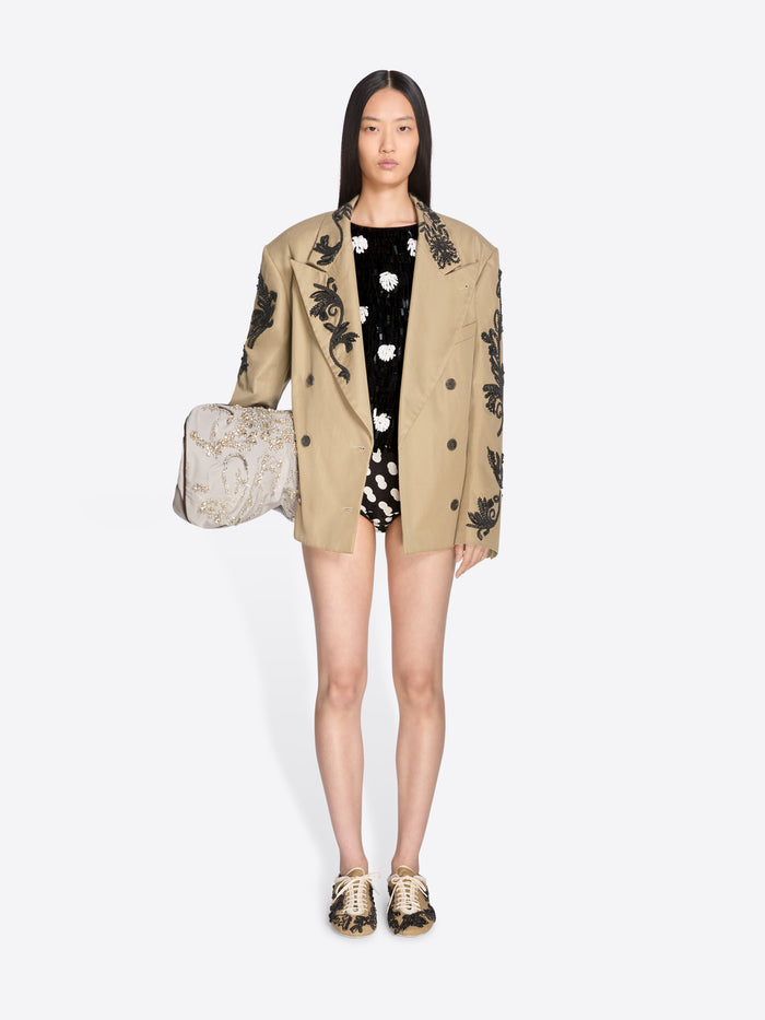 Woman wearing a beige blazer with black floral embroidery on a white background - Dries Van Noten