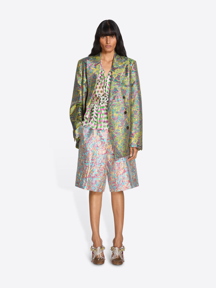 Woman wearing a colorful outfit with a patterned coat and shorts on a white background - Dries Van Noten