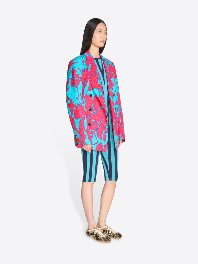 Person wearing a colorful outfit with a pink and blue pattern on a white background - Dries Van Noten