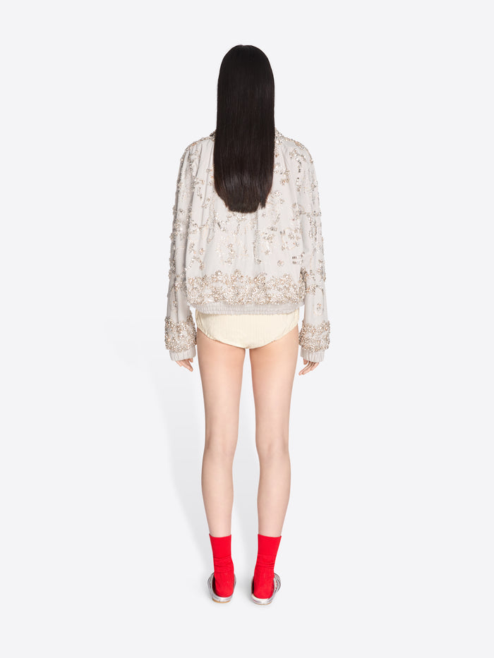 Person wearing a sheer top and red socks on a white background - Dries Van Noten