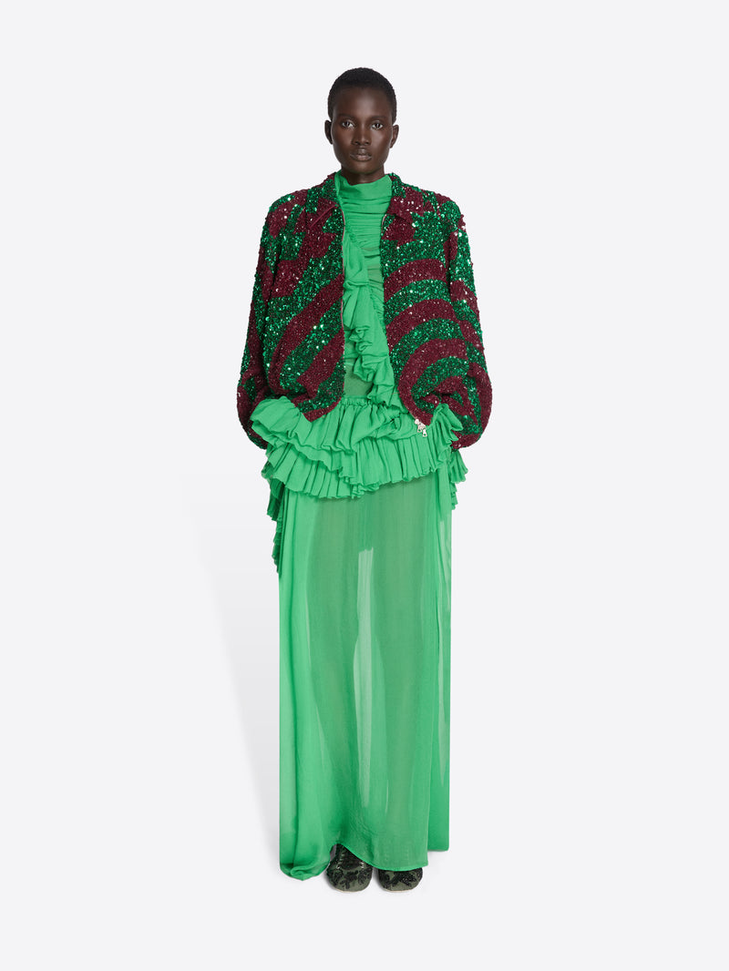 Model wearing a green and red outfit with ruffled elements on a white background - Dries Van Noten