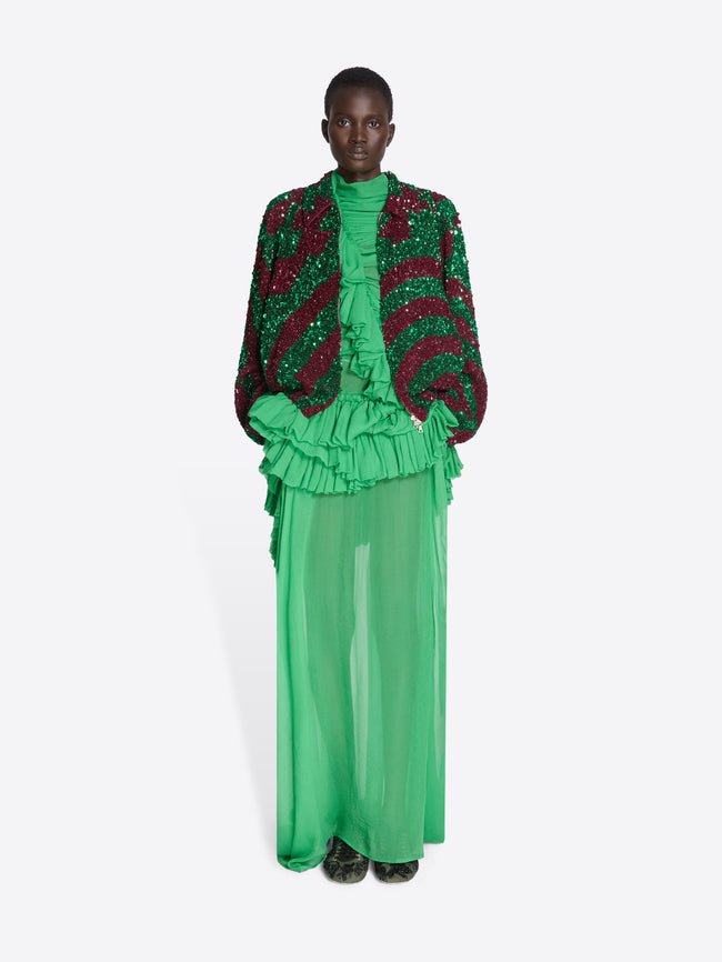 Model wearing a green and red outfit with ruffled elements on a white background - Dries Van Noten
