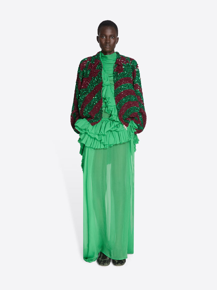 Model wearing a green and red outfit with ruffled elements on a white background - Dries Van Noten