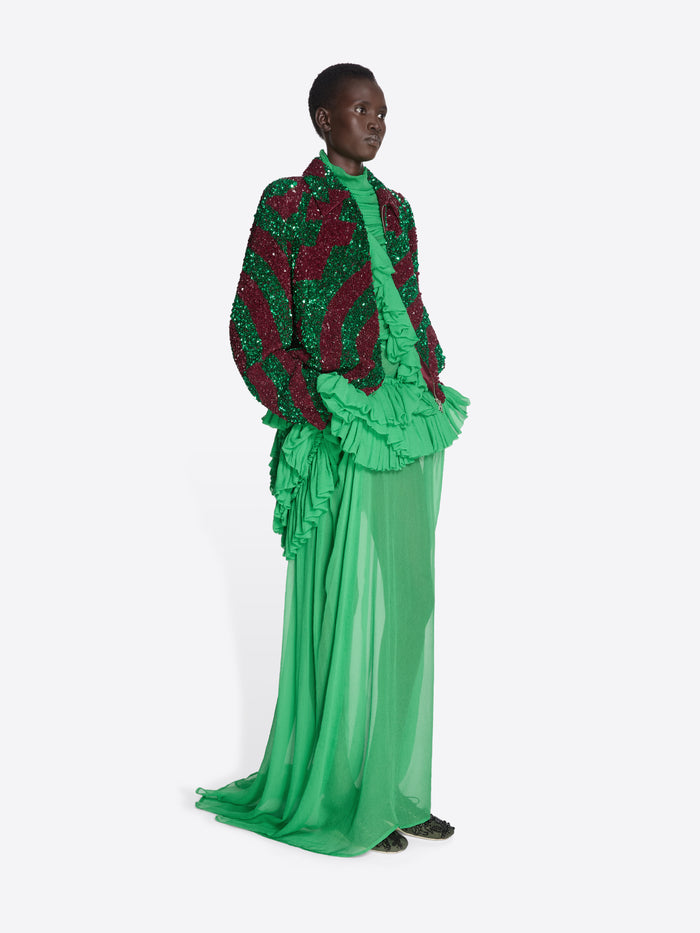 Model wearing a green and red outfit with ruffled details on a white background - Dries Van Noten
