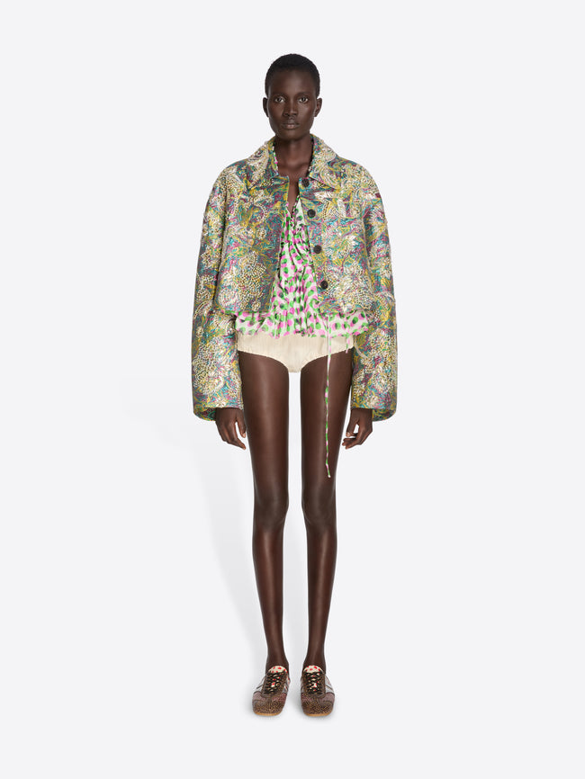 Model wearing a floral jacket and white shorts on a white background - Dries Van Noten