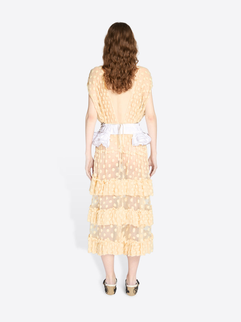 Woman wearing a light yellow dress with ruffled layers on a white background - Dries Van Noten