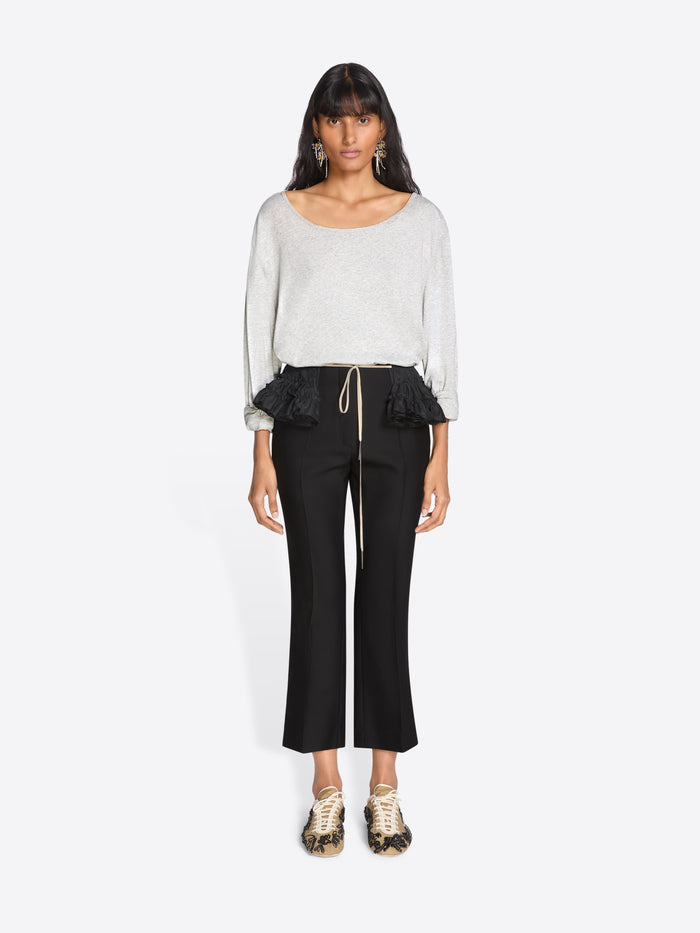 Woman wearing a white top and black pants on a white background - Dries Van Noten