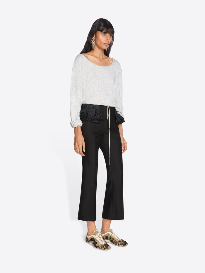 Woman wearing a white top and black pants on a white background - Dries Van Noten