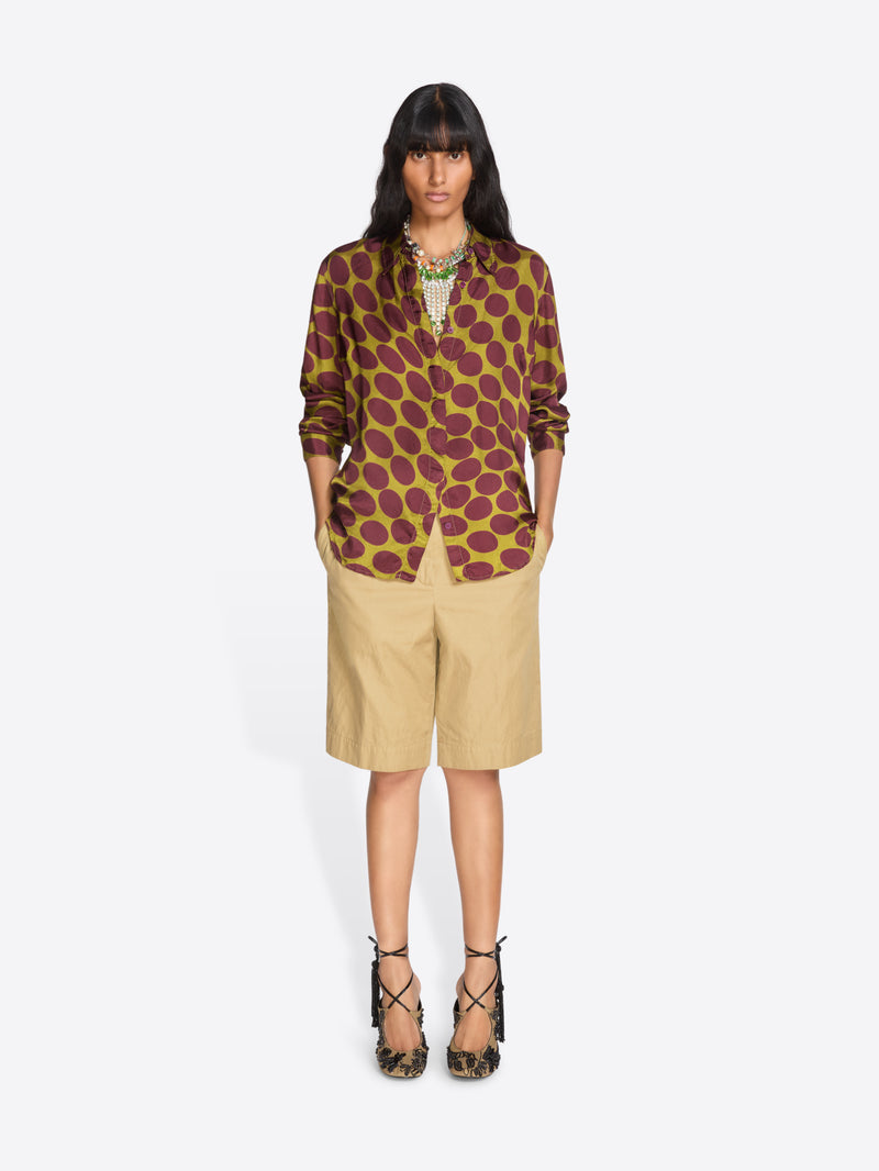 Woman wearing a patterned top and beige shorts on a white background - Dries Van Noten