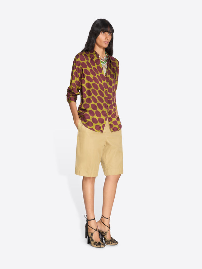 Woman wearing a patterned shirt and beige skirt on a white background - Dries Van Noten