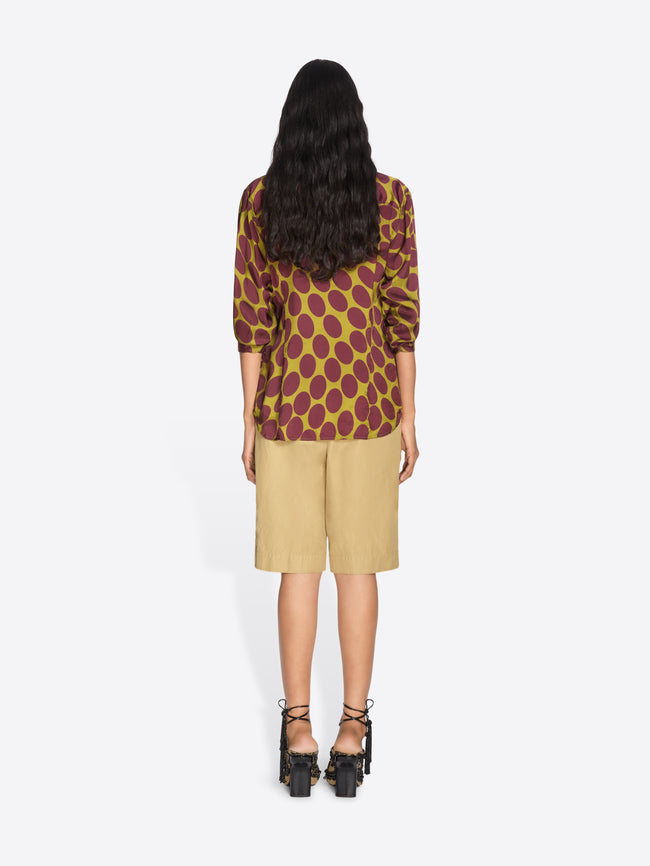 Person wearing a patterned top and beige shorts on a white background - Dries Van Noten