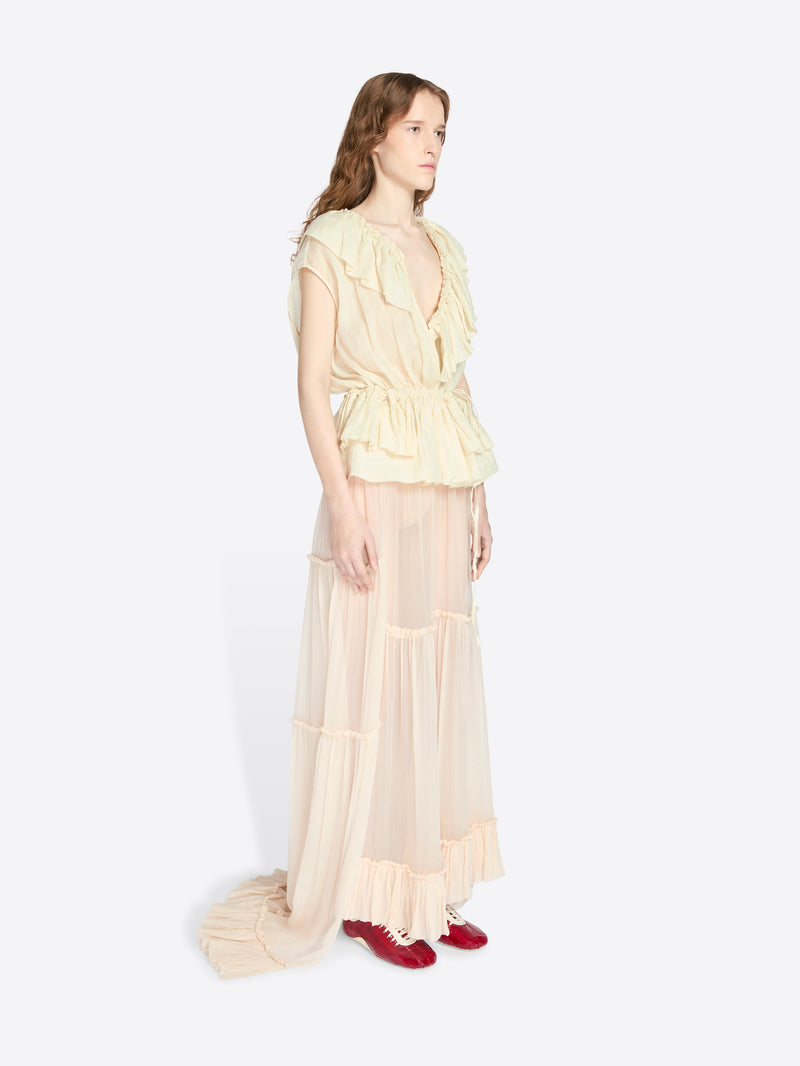 Woman wearing a light-colored set with ruffled details on a white background - Dries Van Noten