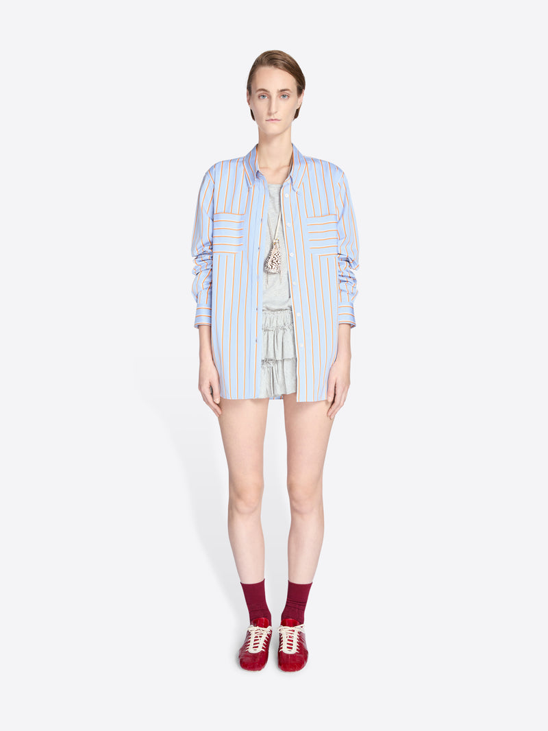 Woman wearing a light blue striped shirt and shorts on a white background - Dries Van Noten