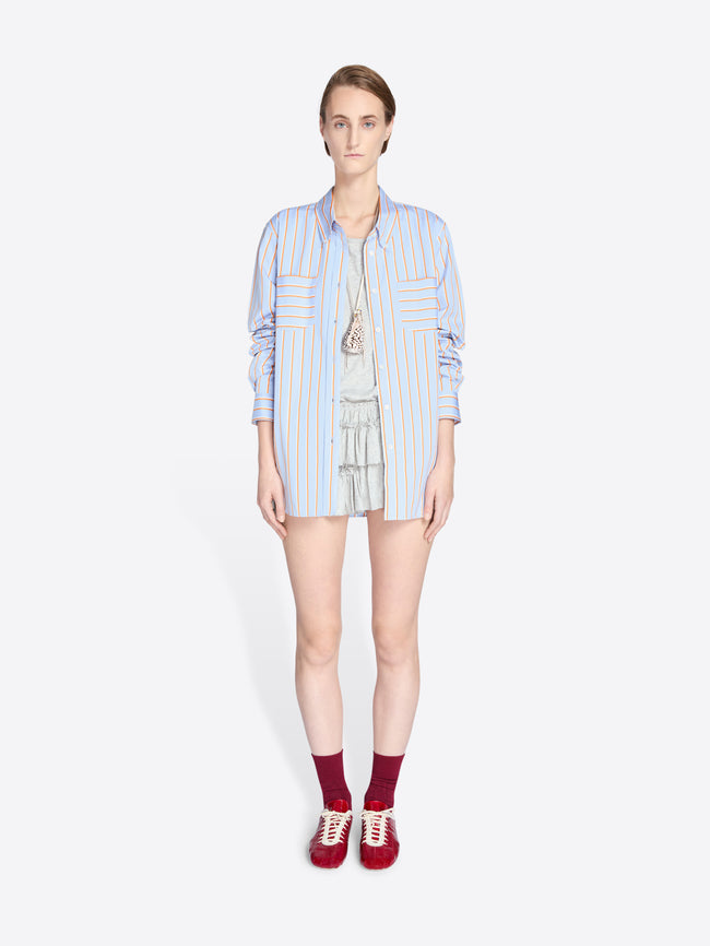 Woman wearing a light blue striped shirt and shorts on a white background - Dries Van Noten