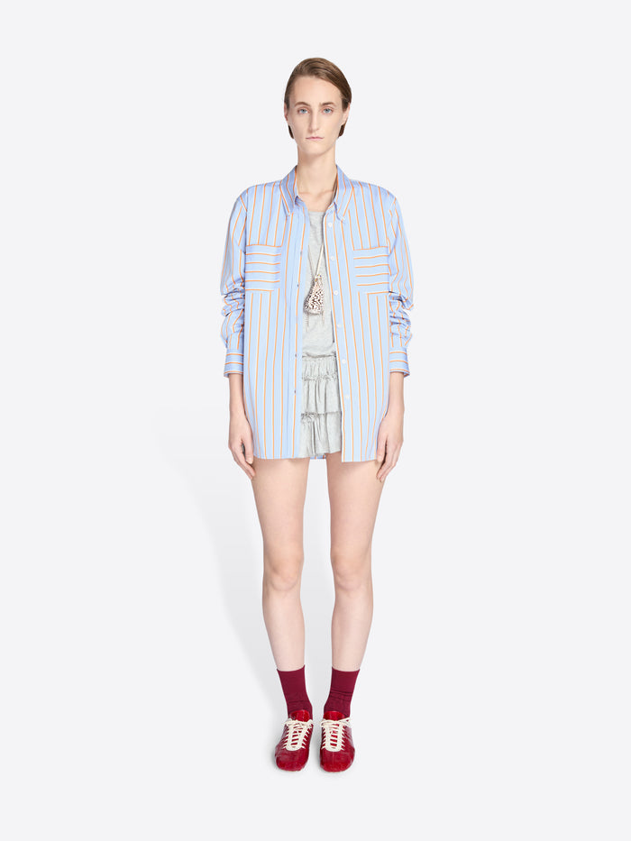 Woman wearing a light blue striped shirt and shorts on a white background - Dries Van Noten