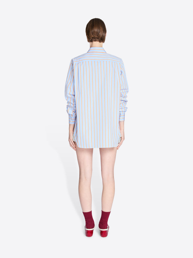 Person wearing a light blue striped shirt on a white background - Dries Van Noten