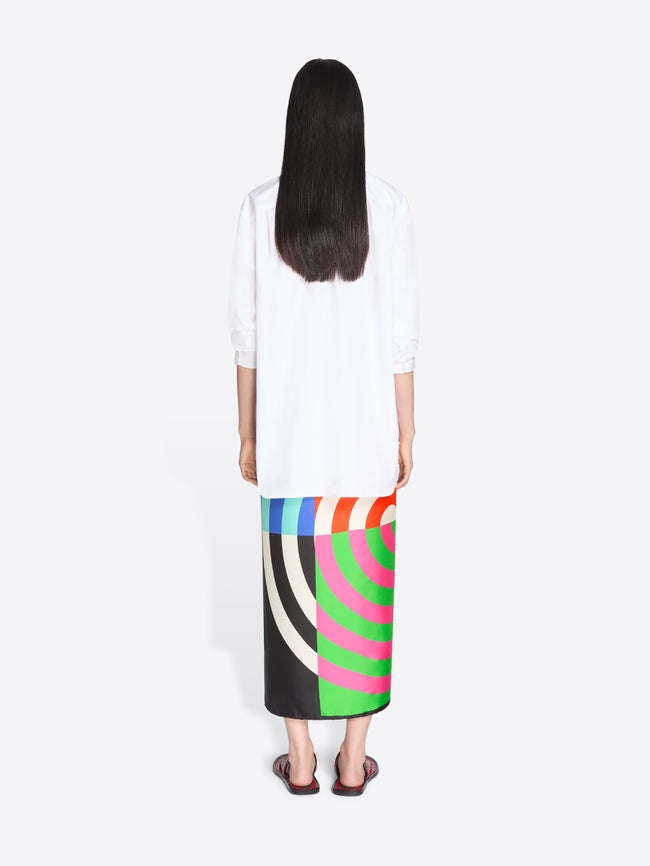 Person wearing a white top and colorful skirt on a white background - Dries Van Noten
