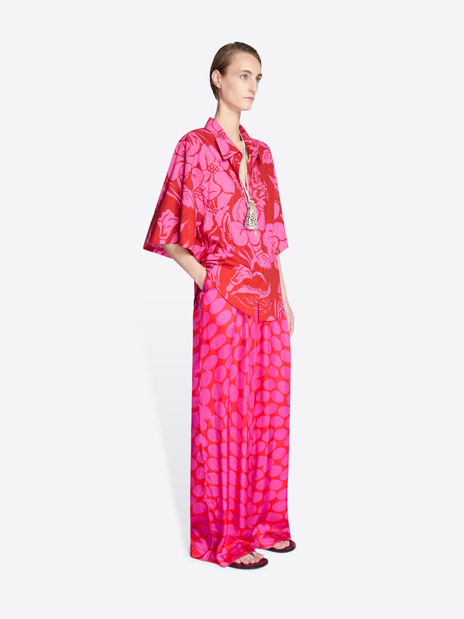 Model wearing a vibrant pink and red patterned outfit on a white background - Dries Van Noten