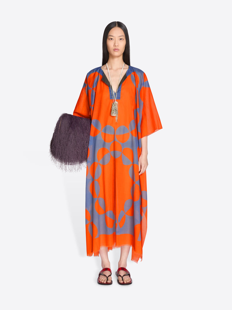 Woman wearing an orange and blue patterned dress with a black bag on a white background - Dries Van Noten
