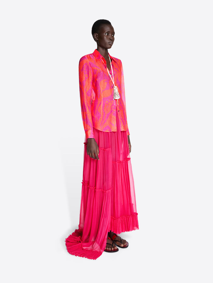 Model wearing a vibrant pink and orange outfit with a long skirt on a white background - Dries Van Noten