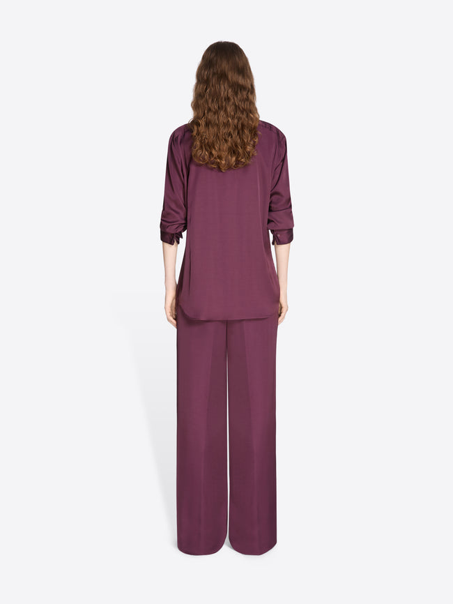 Person wearing a burgundy outfit with wide-leg pants on a white background - Dries Van Noten