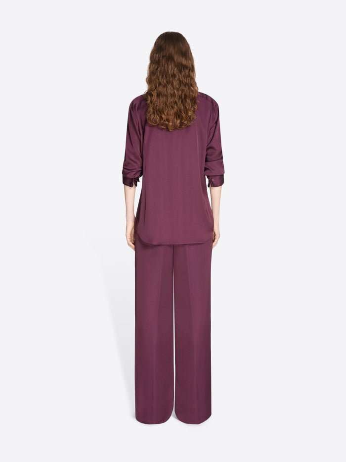 Person wearing a burgundy outfit with wide-leg pants on a white background - Dries Van Noten