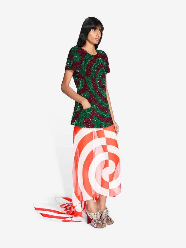 Woman wearing a patterned top and red and white striped skirt on a white background - Dries Van Noten