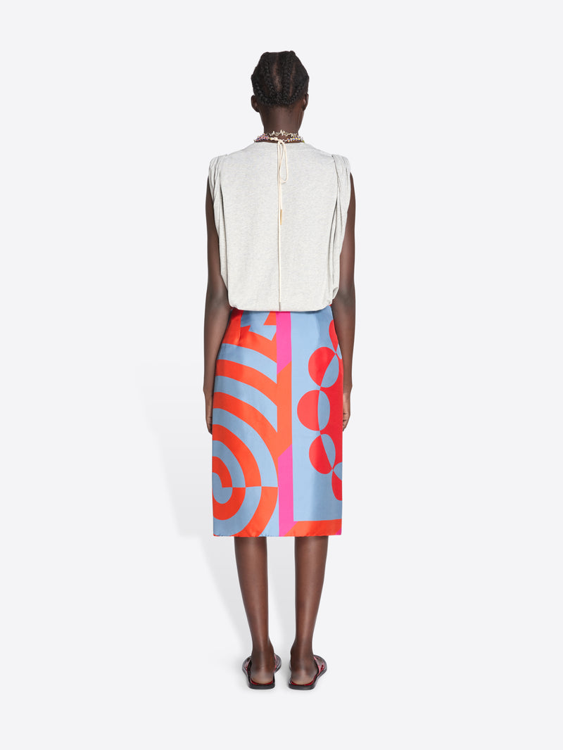 Person wearing a white sleeveless top and colorful patterned skirt on a white background - Dries Van Noten
