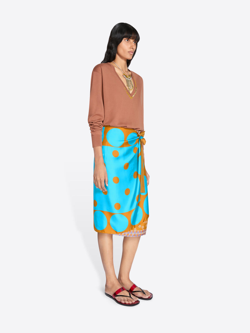 Woman wearing a brown top and blue skirt with orange polka dots on a white background - Dries Van Noten