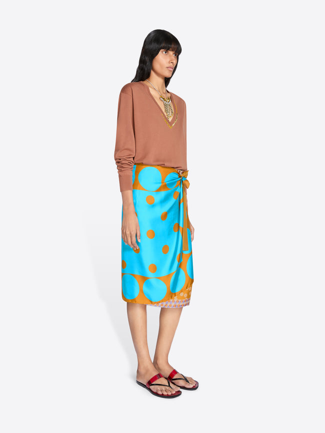 Woman wearing a brown top and blue skirt with orange polka dots on a white background - Dries Van Noten