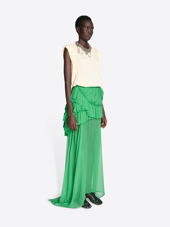 Model wearing a cream top and green ruffled skirt on a white background - Dries Van Noten