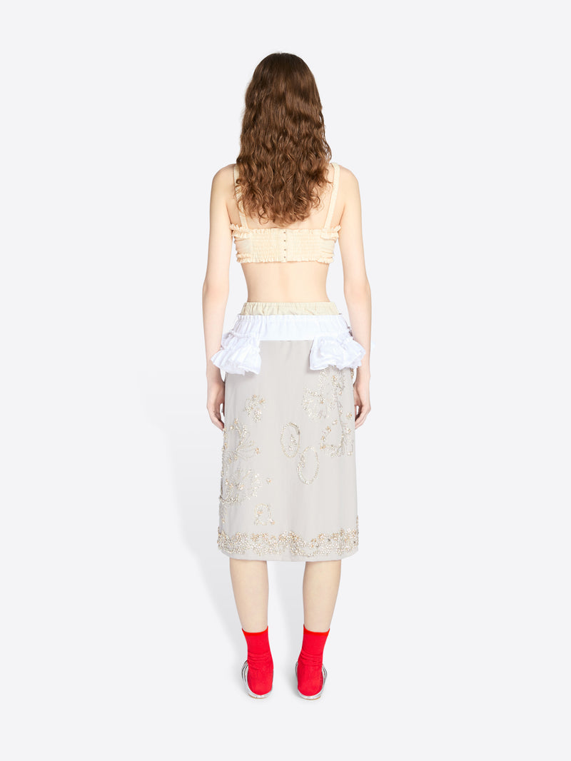 Woman wearing a beige lace top and skirt with red shoes on a white background - Dries Van Noten